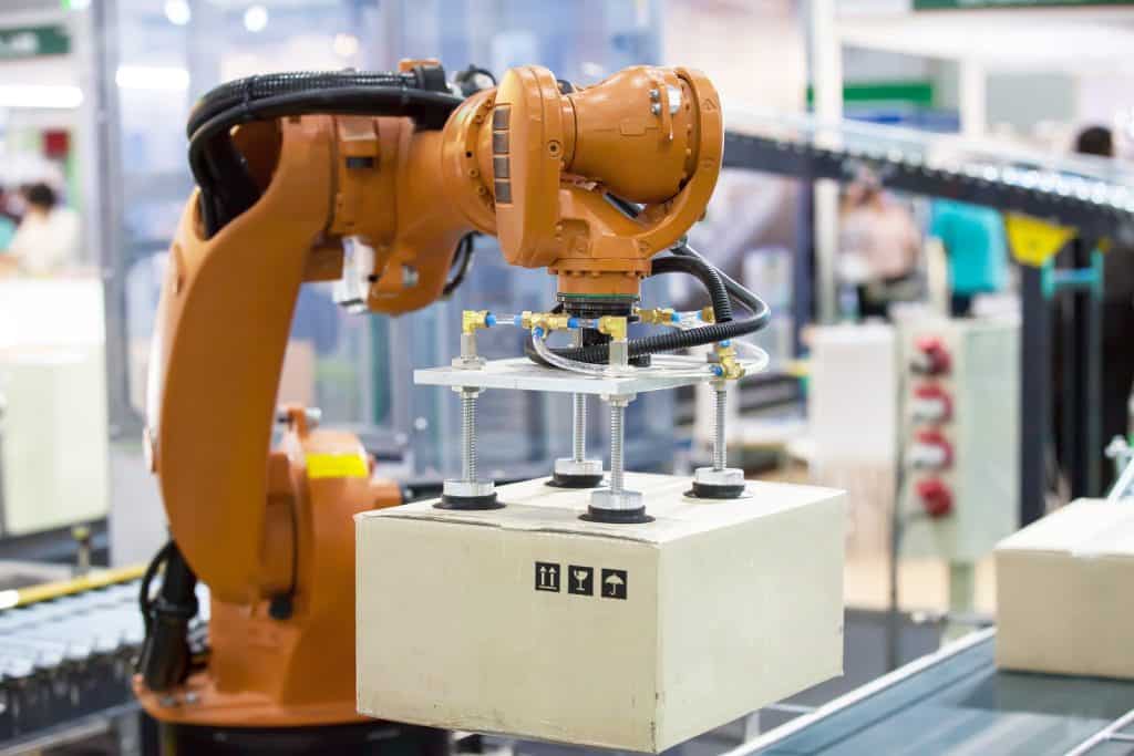 Robotic Arm holding package on manufacturing line